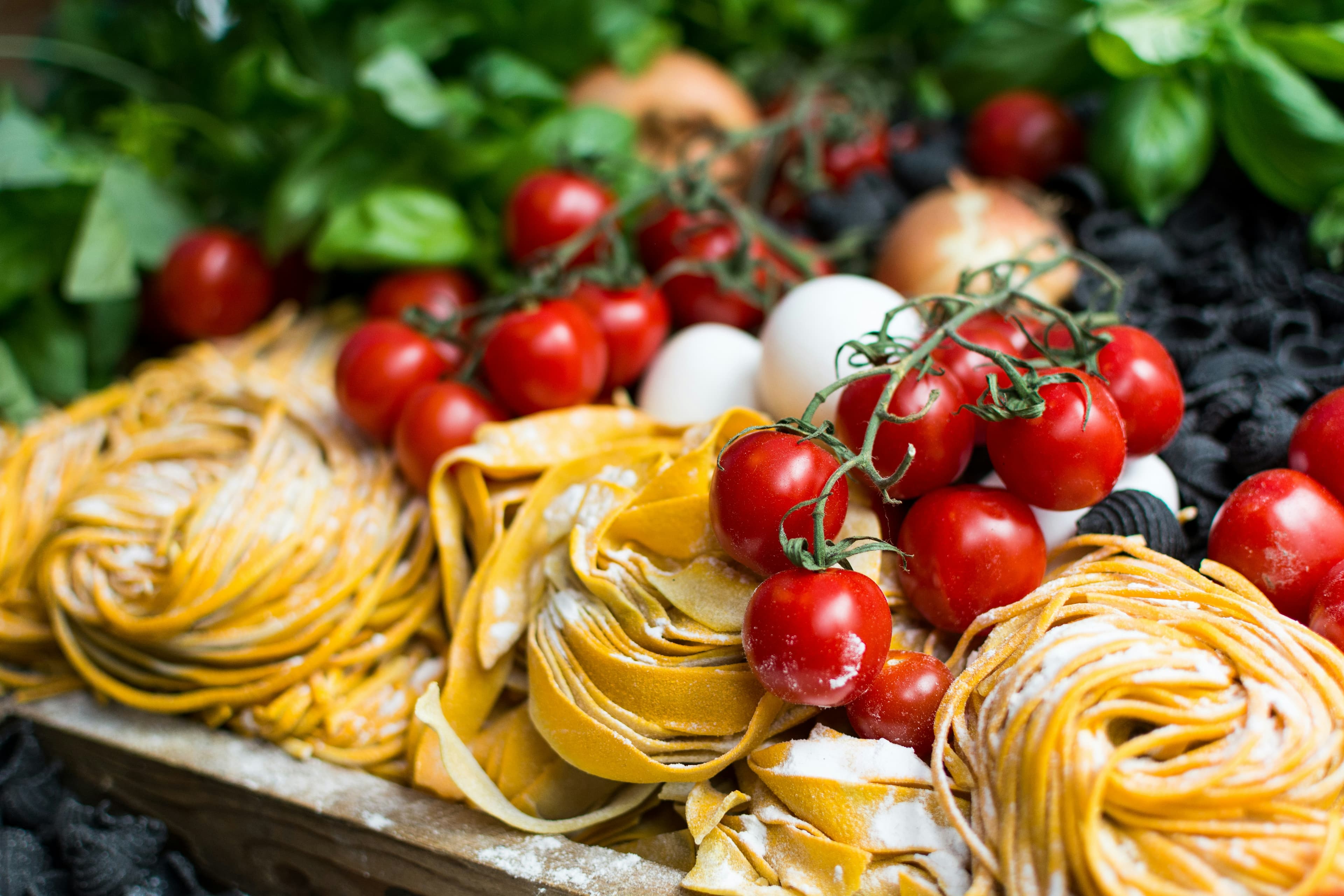 Fresh pasta, tomatoes and garlic on a board