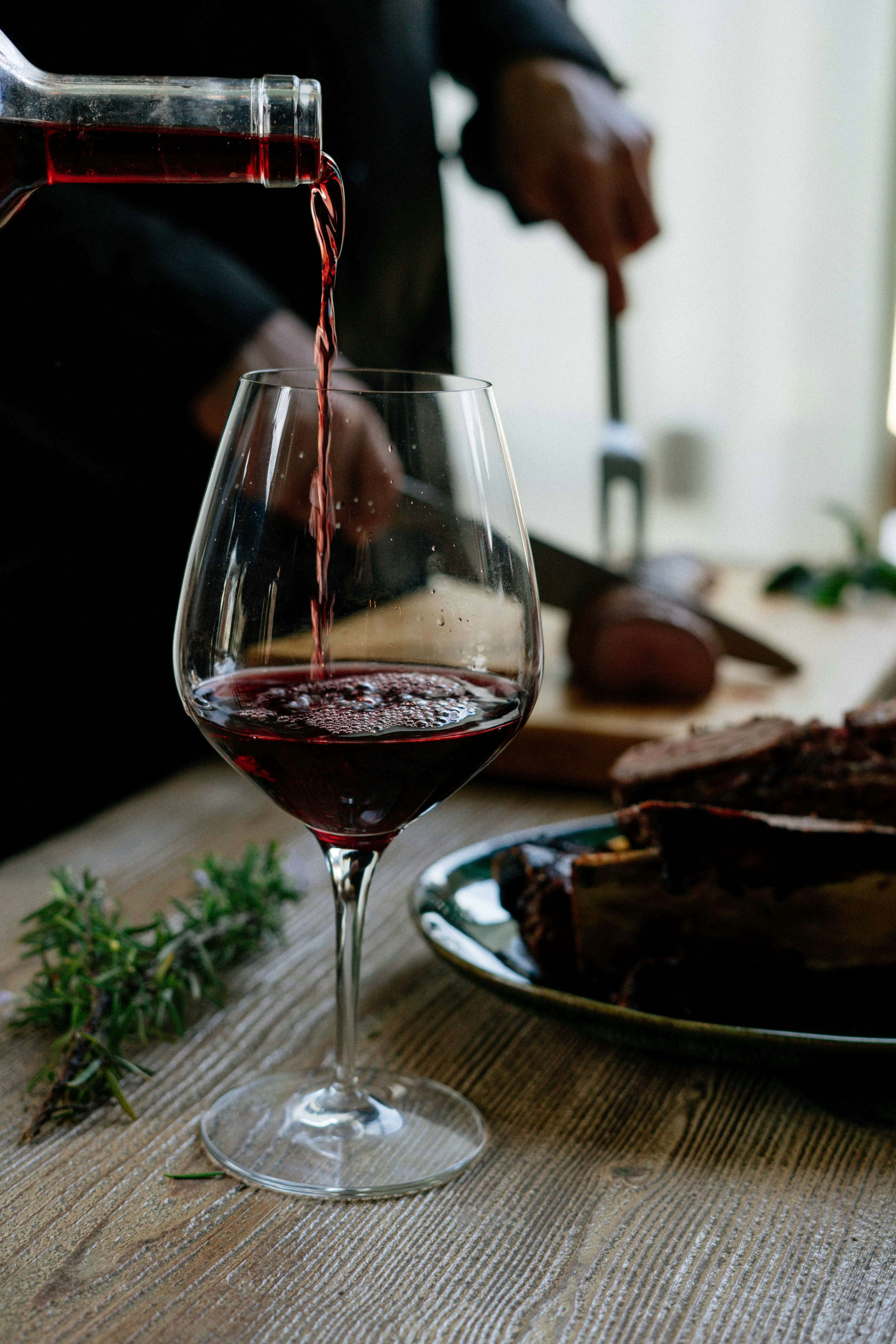 Red wine being poured at a dinner table